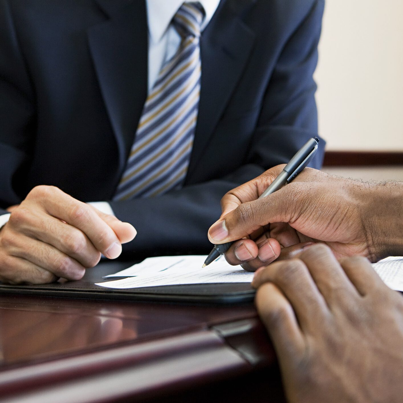 Customer signing paperwork with bank manager